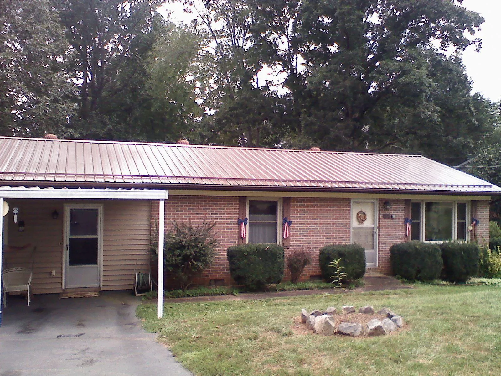 Bronze metal roof and carport on a brick ranch home — Roof Repair work by our crew in Round Top
